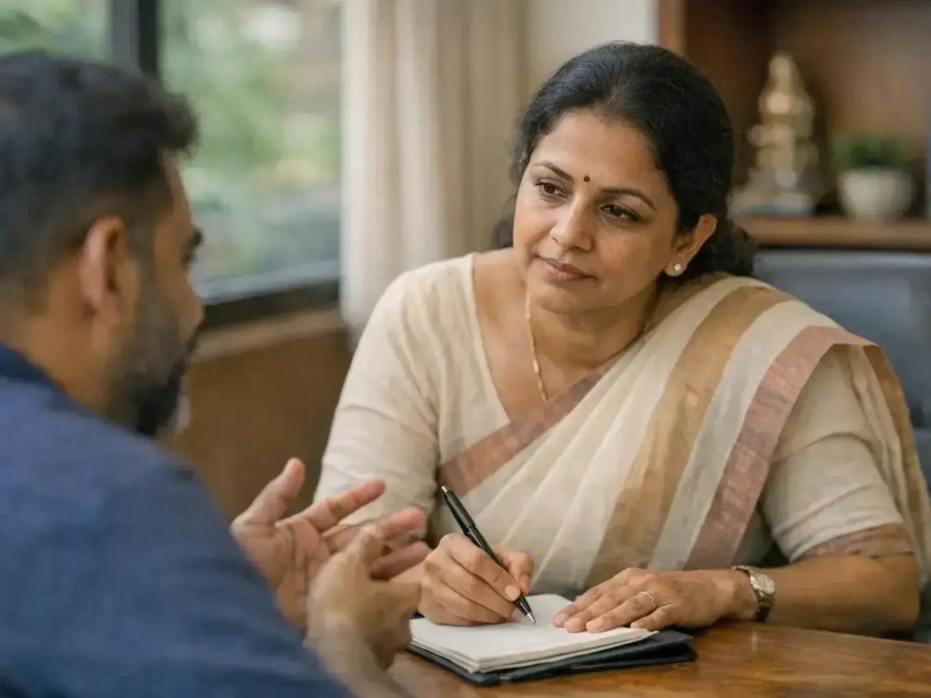 Professional therapist taking notes during confidential mental health assessment